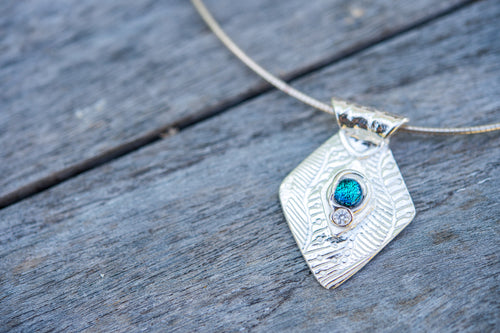 Fine silver diamond shape pendant with a blue dichroic glass